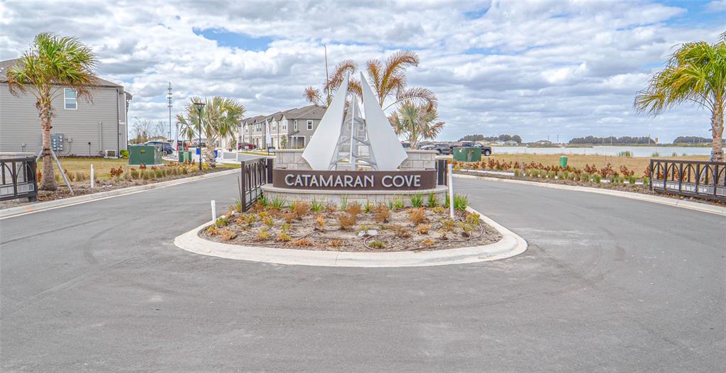 The entrance to Catamaran Cove features a stone monument sign with a sailboat sculpture — 1918 BLUEWATER, ROCKLEDGE, FL