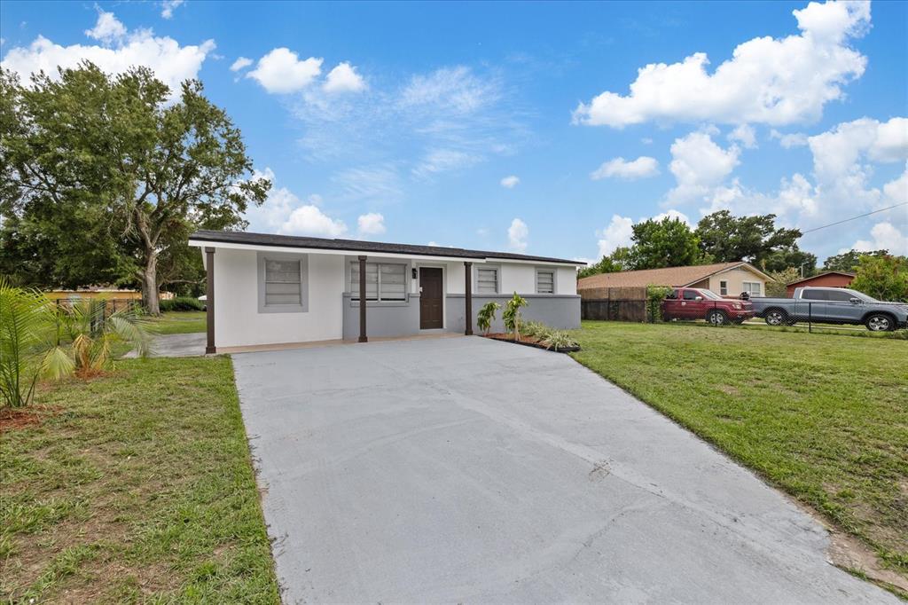 A single-story house with a white and gray exterior, a concrete driveway, and a front porch — 8303 BAHIA AVENUE, TAMPA, FL