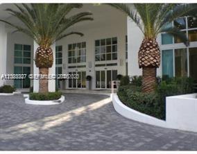 The exterior entrance of a building features a paved driveway and two large palm trees — 951 BRICKELL AV # 3401, Miami FL 33131, MIAMI, FL