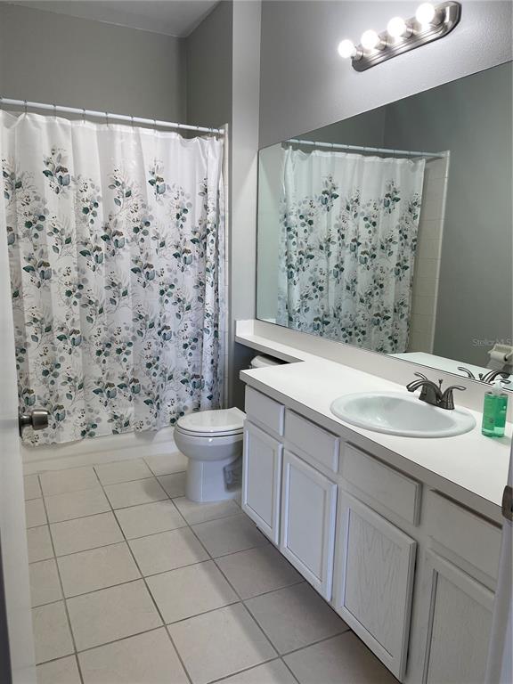 A bathroom features a white vanity, a large mirror, a toilet, and a shower curtain — 13180 SUMMERTON DRIVE, ORLANDO, FL