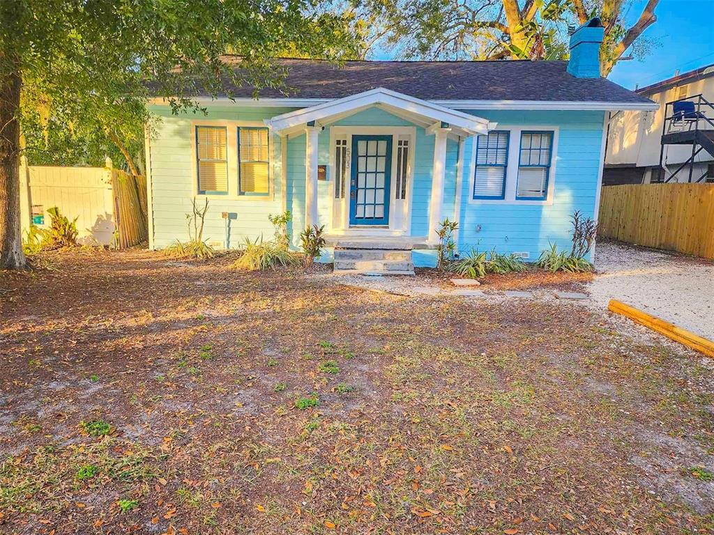 A light blue bungalow with a white front porch and a dark blue front door — 503 W IDLEWILD AVENUE, TAMPA, FL