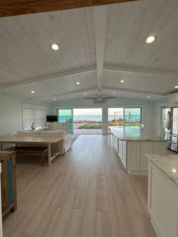 An open-concept kitchen and living area features a vaulted wood ceiling and ocean views — 5 PARK AVENUE, SATELLITE BEACH, FL