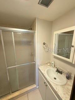 A bathroom features a glass-enclosed shower, a vanity with a sink, and a medicine cabinet — 1475 FLAMINGO DRIVE UNIT 142, ENGLEWOOD, FL