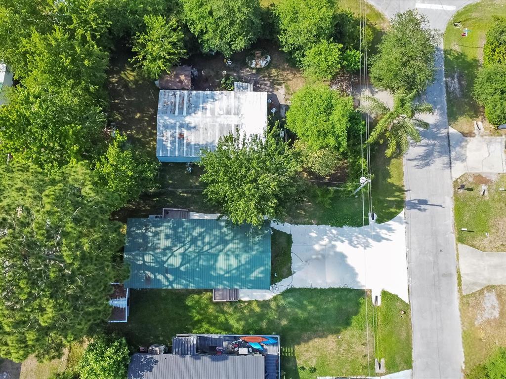 An aerial view shows a house with a green roof, a driveway, and surrounding trees — 54735 WILLIAMS STREET, ASTOR, FL