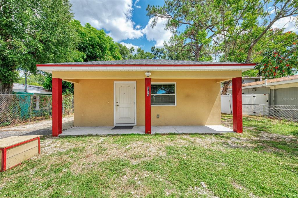A single-story house with a covered front porch, red support columns, and a white door — 1420 19TH AVENUE W, BRADENTON, FL
