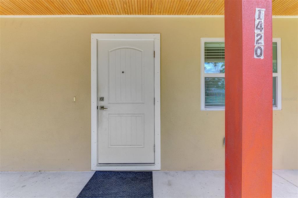 A front entrance features a white door, a window, and a red support post — 1420 19TH AVENUE W, BRADENTON, FL