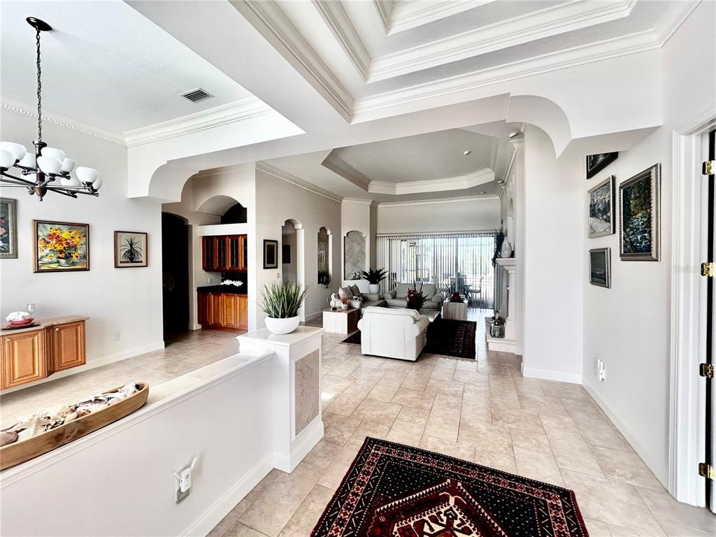 A spacious living area features tile floors, a tray ceiling, and a wet bar area — 9110 DEER COURT, VENICE, FL