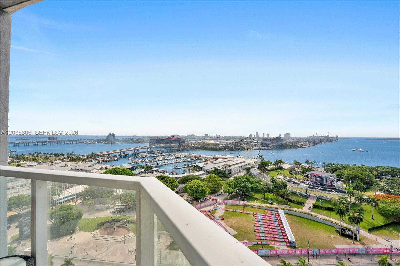 A high-angle view from a balcony overlooks a park, a marina, and a cruise port — 244 Biscayne Blvd # 1803, Miami FL 33132, MIAMI, FL