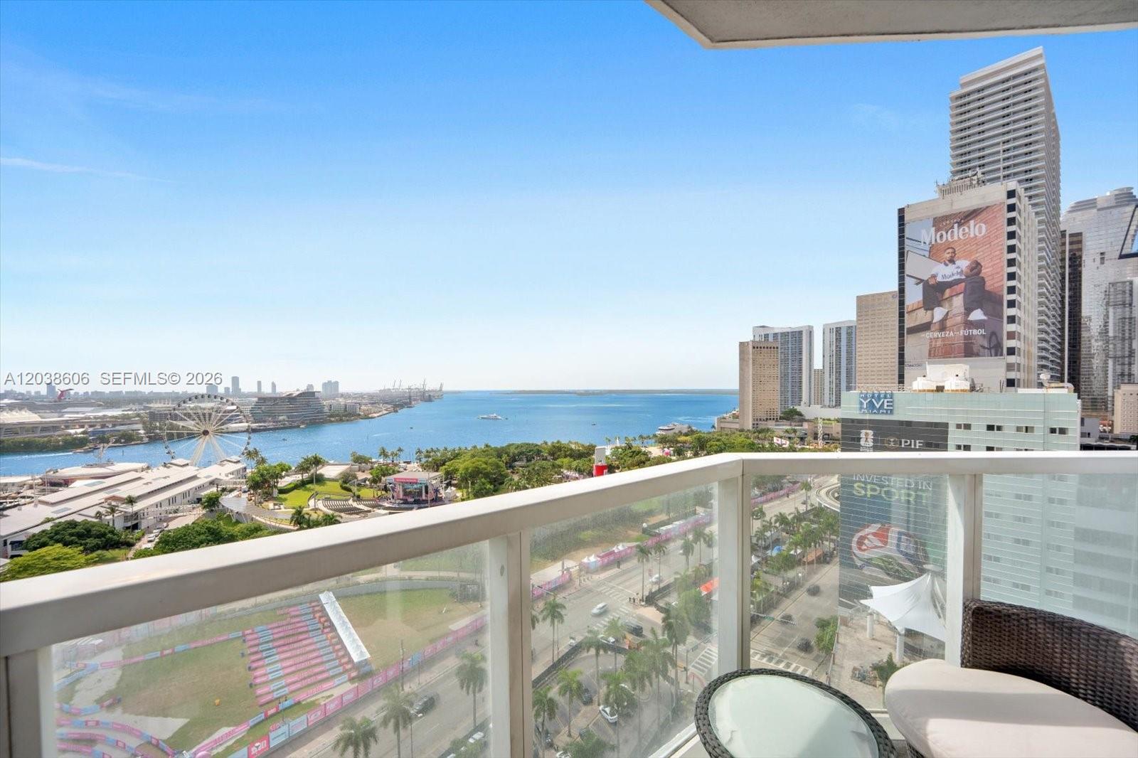 A balcony view overlooks a park, a Ferris wheel, the bay, and city skyscrapers — 244 Biscayne Blvd # 1803, Miami FL 33132, MIAMI, FL