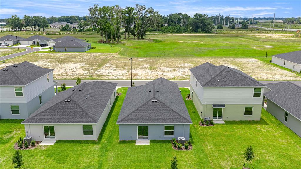 An aerial view shows the backyards and rear exteriors of several suburban houses — 4452 SW 80TH PLACE, OCALA, FL