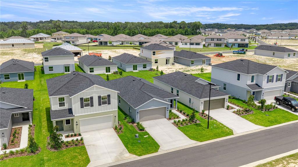 An aerial view shows several newly constructed suburban houses with driveways and green lawns — 4452 SW 80TH PLACE, OCALA, FL