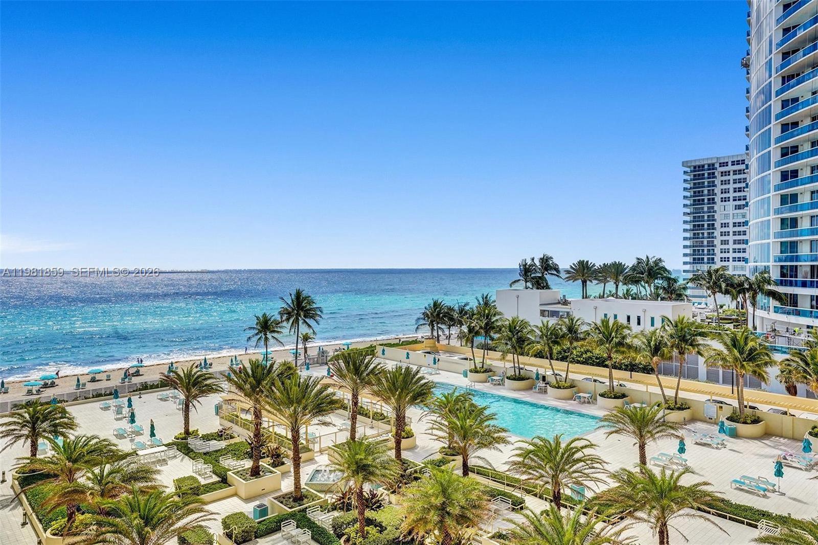 An elevated view of a beachside swimming pool surrounded by palm trees and high-rise buildings — 2501 S Ocean Dr, Hollywood FL 33019, HOLLYWOOD, FL
