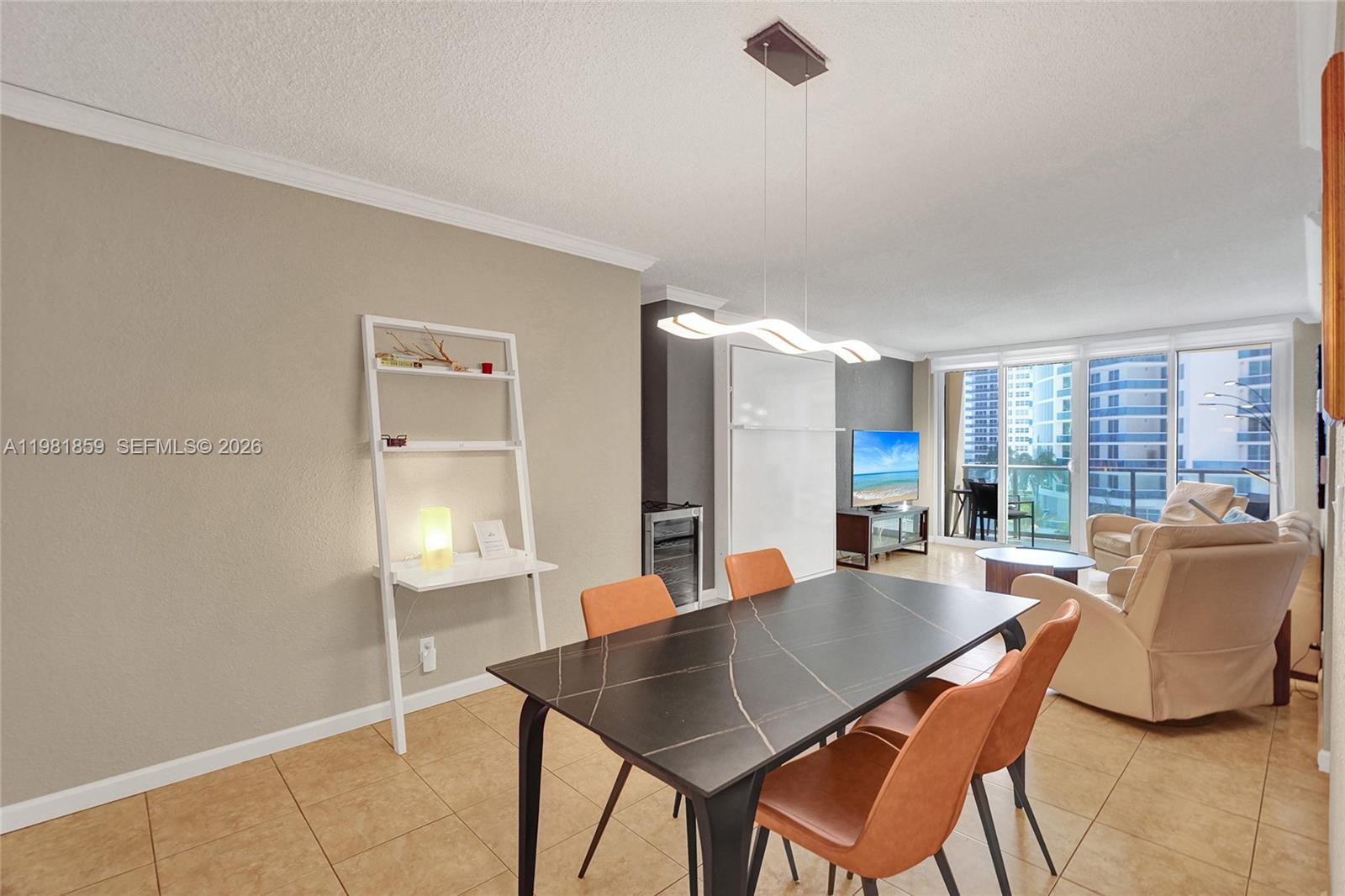 A dining area with a dark marble table and orange chairs sits before a living space — 2501 S Ocean Dr, Hollywood FL 33019, HOLLYWOOD, FL