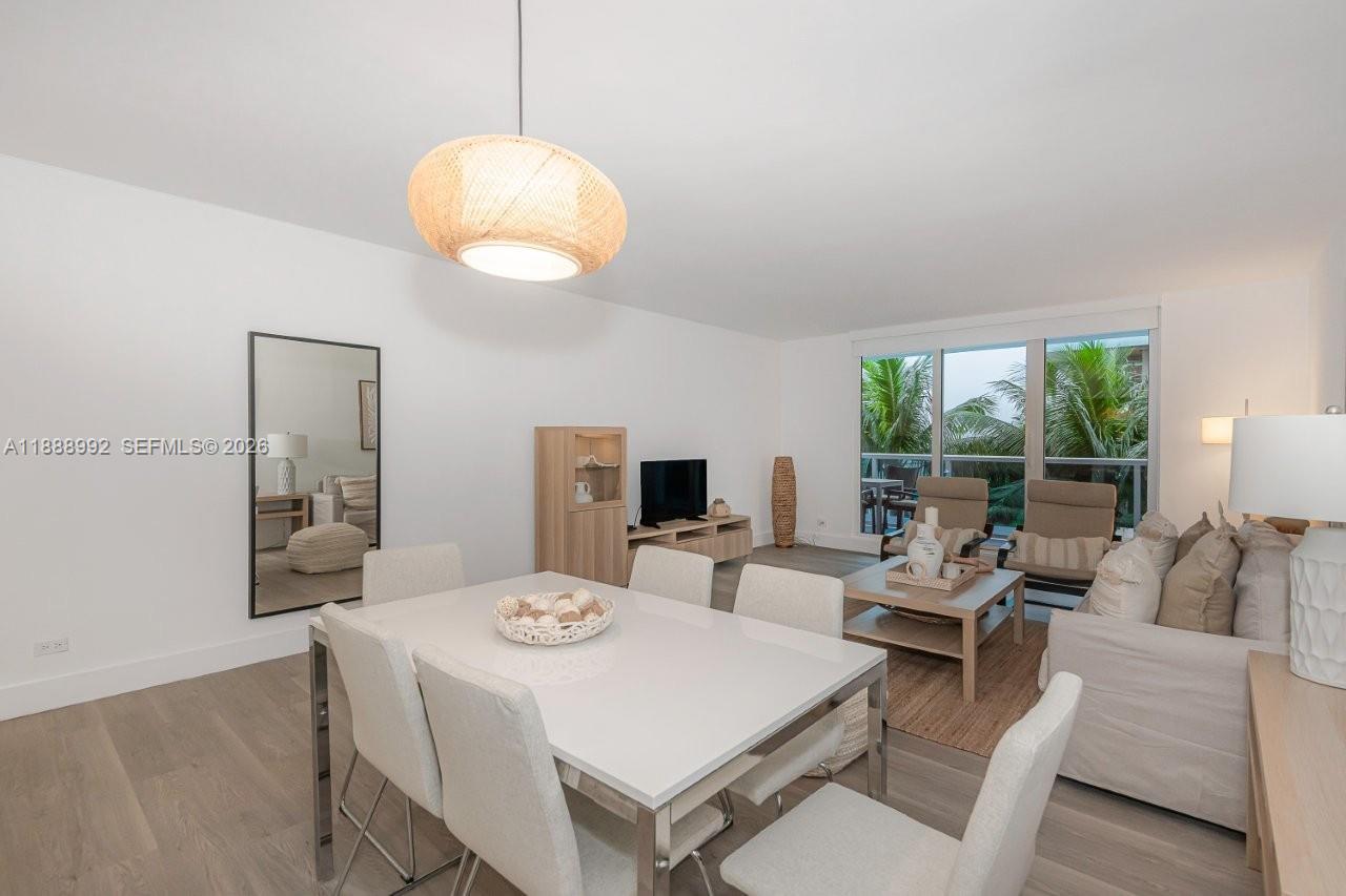 A bright living and dining area features white furniture, light wood floors, and large windows — 2301 Collins Ave # 333, Miami Beach FL 33139, MIAMI BEACH, FL