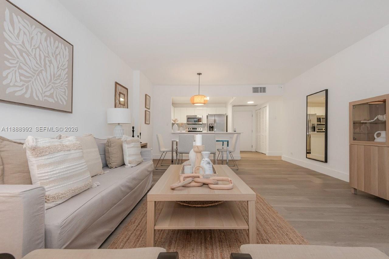 A living room features a light-colored sofa, a wooden coffee table, and an open kitchen — 2301 Collins Ave # 333, Miami Beach FL 33139, MIAMI BEACH, FL