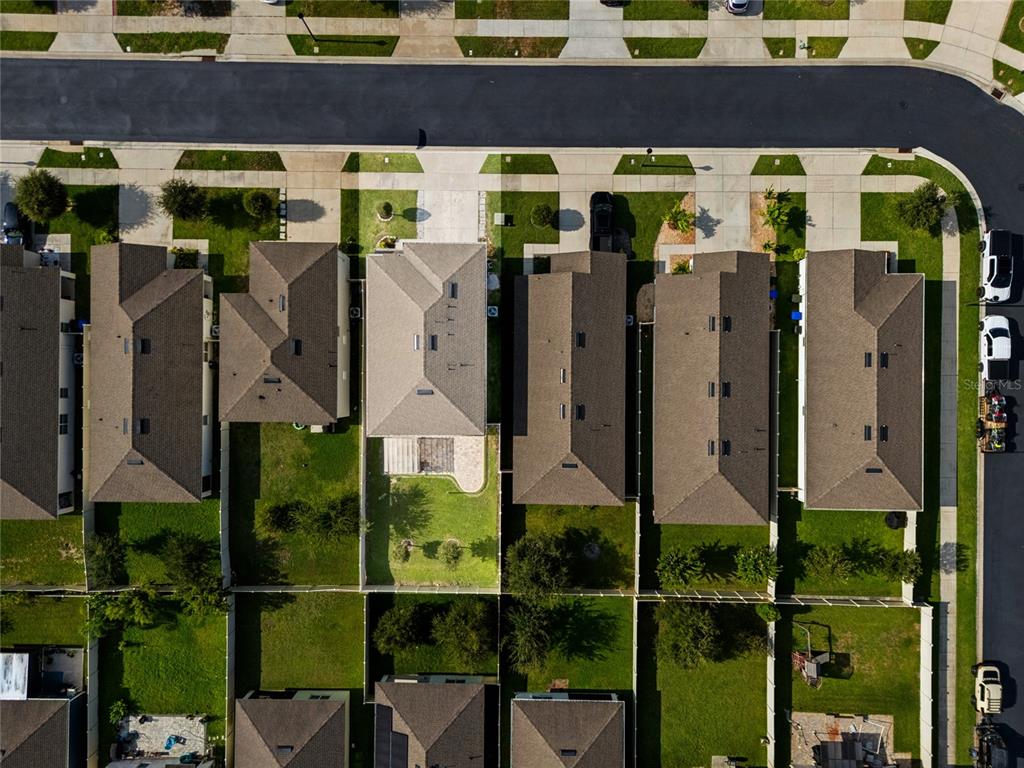An aerial view shows a row of suburban houses with fenced backyards and paved driveways — 3057 TIMBER HAWK CIRCLE, OCOEE, FL
