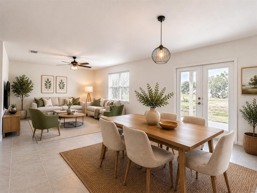 An open-concept living and dining area features neutral furniture, green accents, and tile flooring — 6969 FABEN LANE, ZEPHYRHILLS, FL