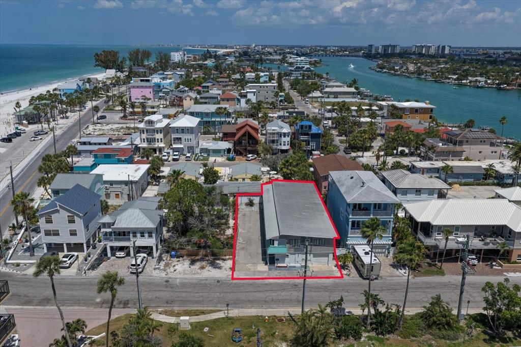 An aerial view shows a rectangular property outlined in red featuring a multi-story building — 40 77TH AVENUE, TREASURE ISLAND, FL