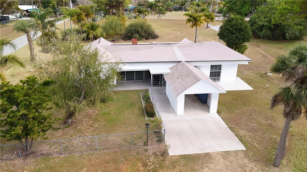 An aerial view shows a white single-story house with a carport and a screened porch — 6386 SCOTT STREET, PUNTA GORDA, FL