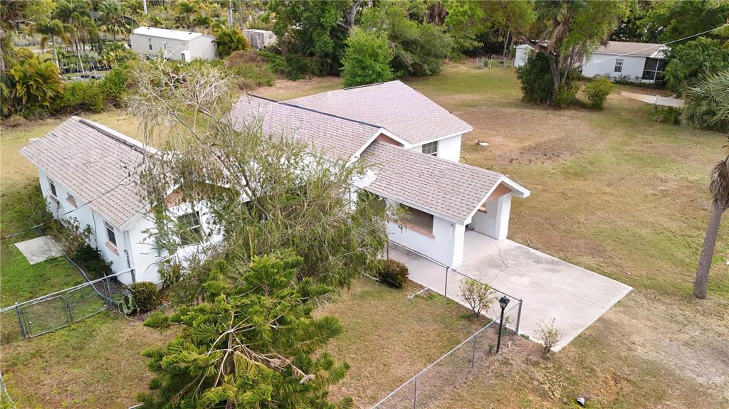An aerial view shows a white house with a shingled roof and a concrete driveway — 6386 SCOTT STREET, PUNTA GORDA, FL