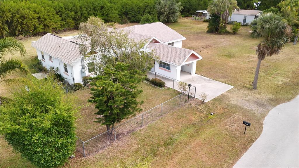 An aerial view of a white single-story house with a carport and fenced yard — 6386 SCOTT STREET, PUNTA GORDA, FL