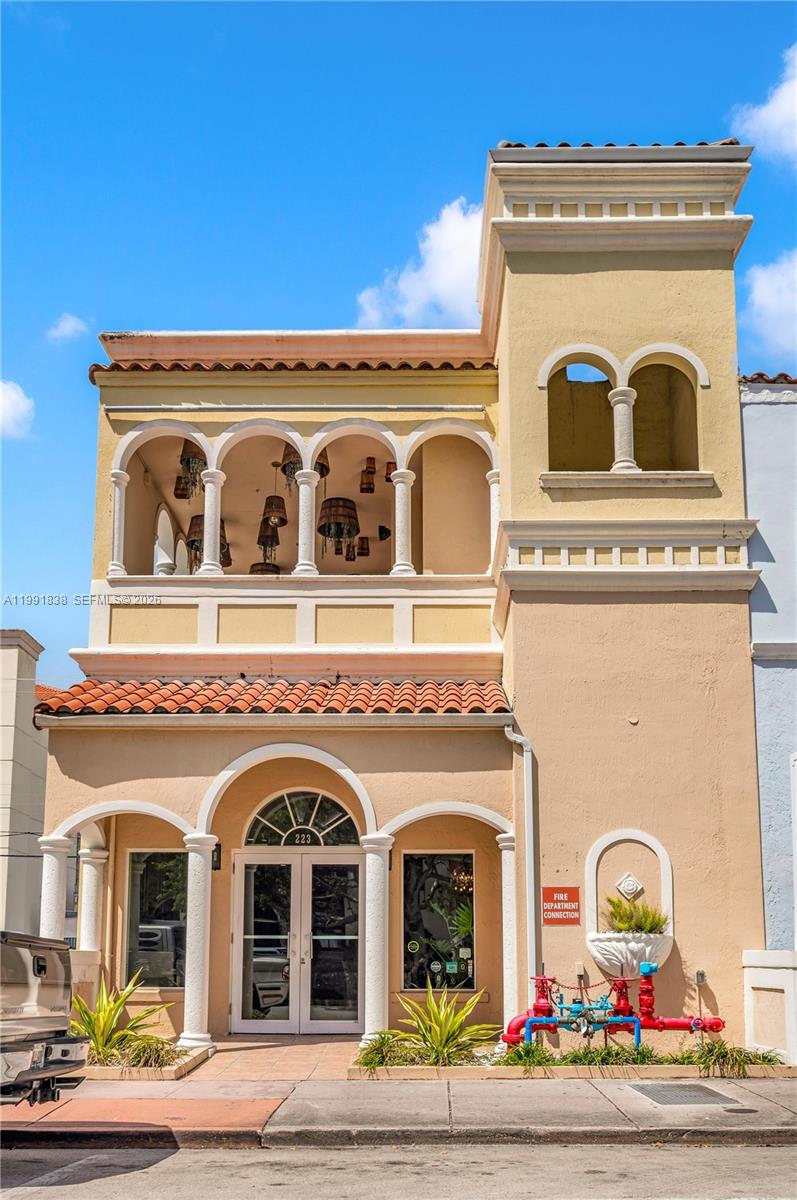 A two-story stucco building with arched windows, a balcony, and a fire department connection — 223 Valencia Ave, Coral Gables FL 33134, CORAL GABLES, FL