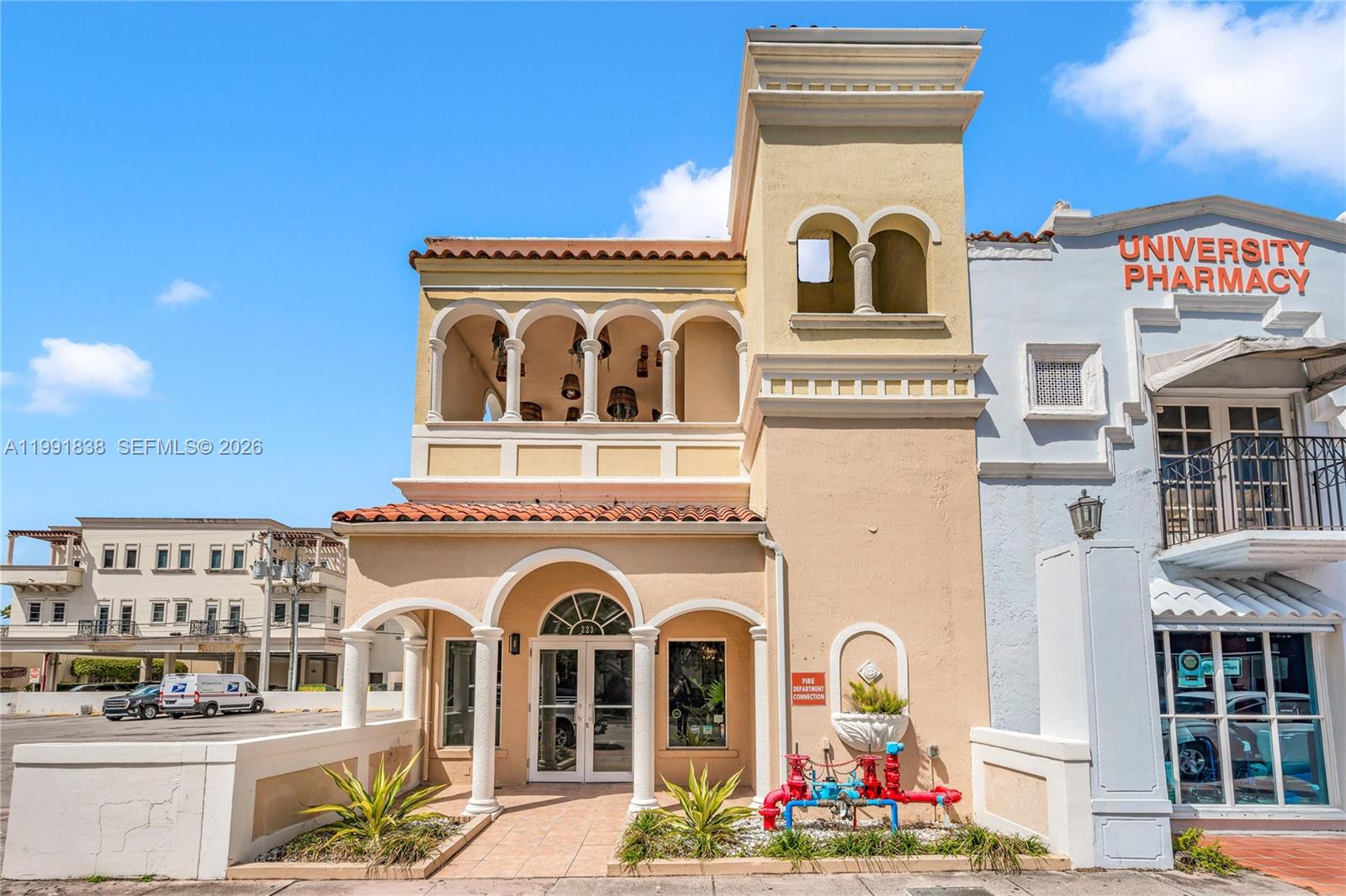 The exterior of a tan, two-story commercial building features arched entryways and a fire connection — 223 Valencia Ave, Coral Gables FL 33134, CORAL GABLES, FL