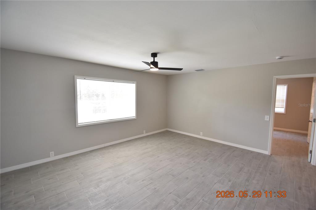 An empty bedroom features gray walls, wood-look tile flooring, and a black ceiling fan — 4060 N LITTLE HAWK POINT, CRYSTAL RIVER, FL