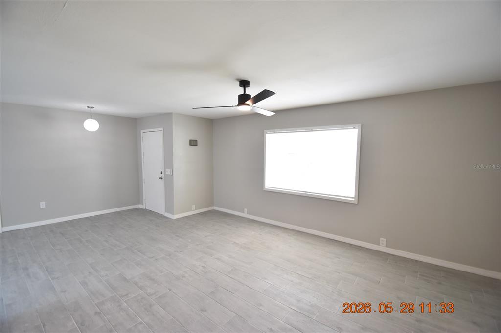 A living room features light gray walls, wood-look tile flooring, a ceiling fan, and a window — 4060 N LITTLE HAWK POINT, CRYSTAL RIVER, FL