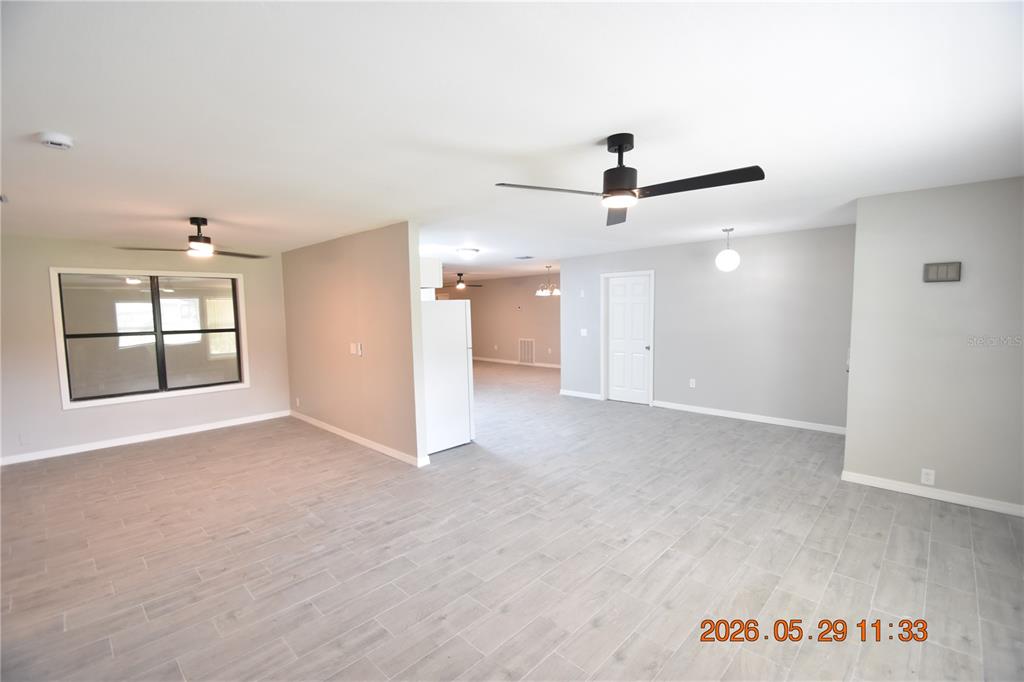 An open-concept living area features light gray tile flooring, white walls, and two ceiling fans — 4060 N LITTLE HAWK POINT, CRYSTAL RIVER, FL