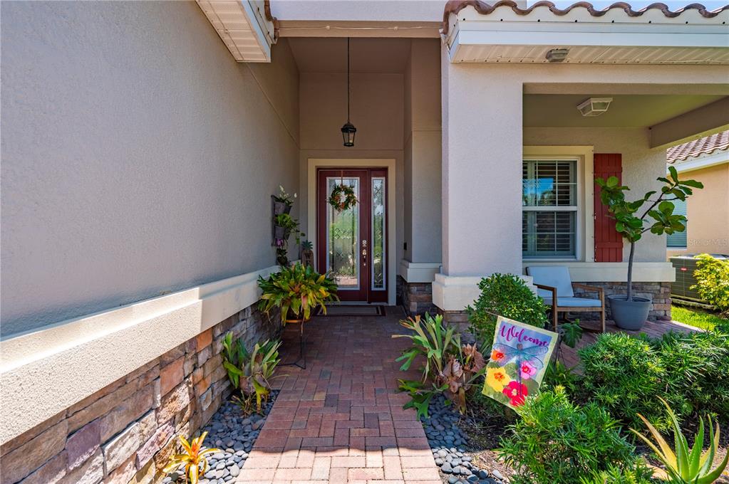 A brick walkway leads to a front door with a wreath under a covered entryway — 3006 ORIOLE DRIVE, SARASOTA, FL