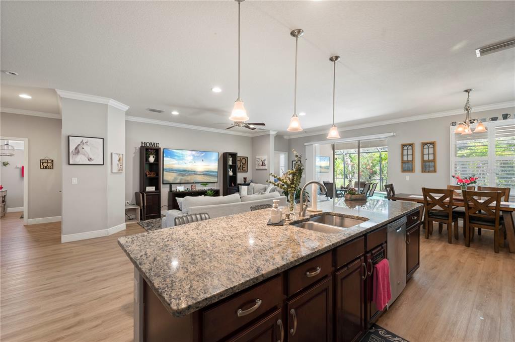 A kitchen island with granite countertops overlooks an open-concept living and dining area — 3006 ORIOLE DRIVE, SARASOTA, FL