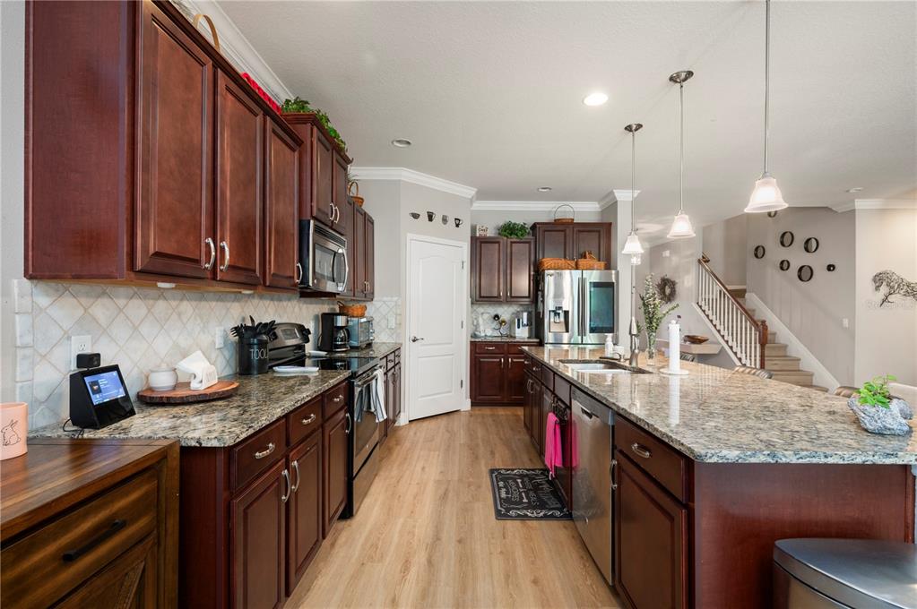 A kitchen features dark wood cabinets, granite countertops, stainless steel appliances, and a central island — 3006 ORIOLE DRIVE, SARASOTA, FL