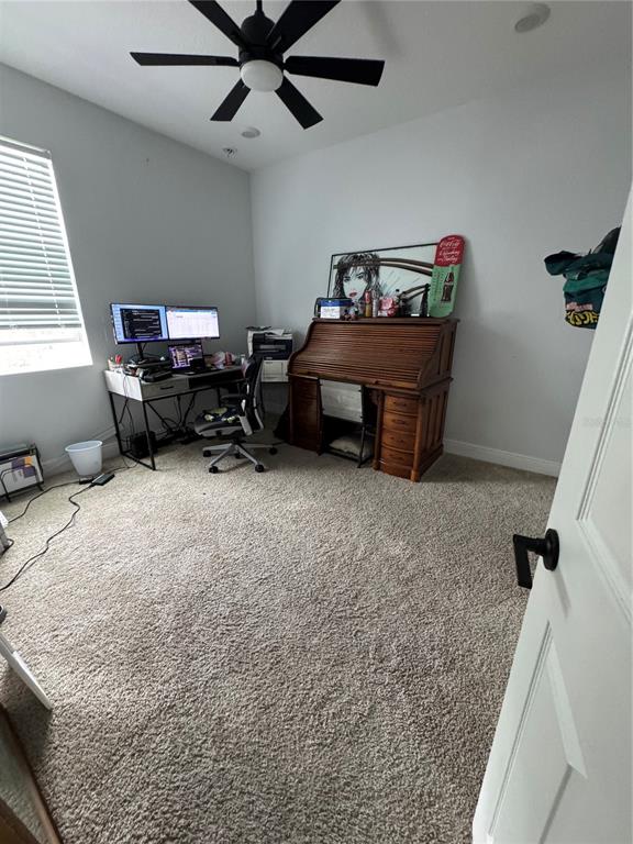 A home office features a desk with dual monitors, a roll-top desk, and carpeted flooring — 515 5TH STREET S, DUNDEE, FL