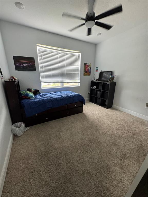 A bedroom features a twin bed, a black storage unit, and a ceiling fan — 515 5TH STREET S, DUNDEE, FL