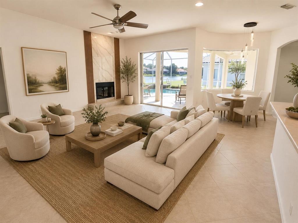 A bright living room features a fireplace, sectional sofa, and a dining area overlooking a pool — 7468 ROXYE LANE, SARASOTA, FL