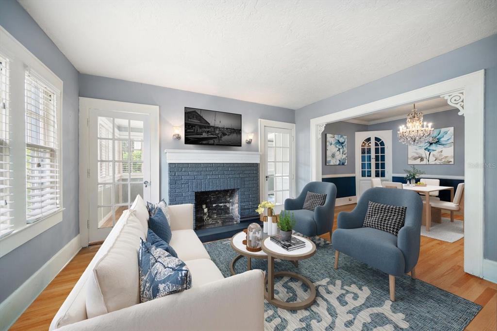 A living room features a blue brick fireplace, white sofa, two blue armchairs, and hardwood floors — 310 N LINCOLN AVENUE, CLEARWATER, FL