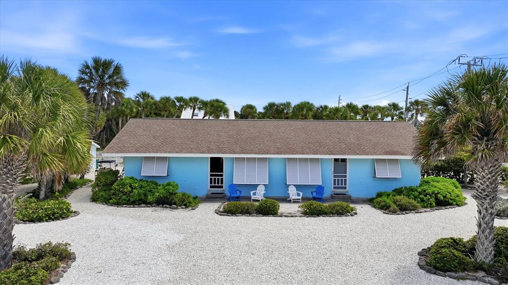 A single-story blue house with a shingled roof sits behind a white gravel driveway — 201 WHEELER ROAD, BOCA GRANDE, FL