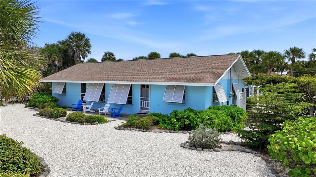 A light blue, single-story house with a brown shingled roof sits on a gravel lot — 201 WHEELER ROAD, BOCA GRANDE, FL