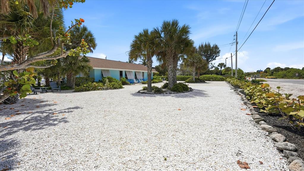 A light blue house sits behind a large gravel yard with palm trees — 201 WHEELER ROAD, BOCA GRANDE, FL