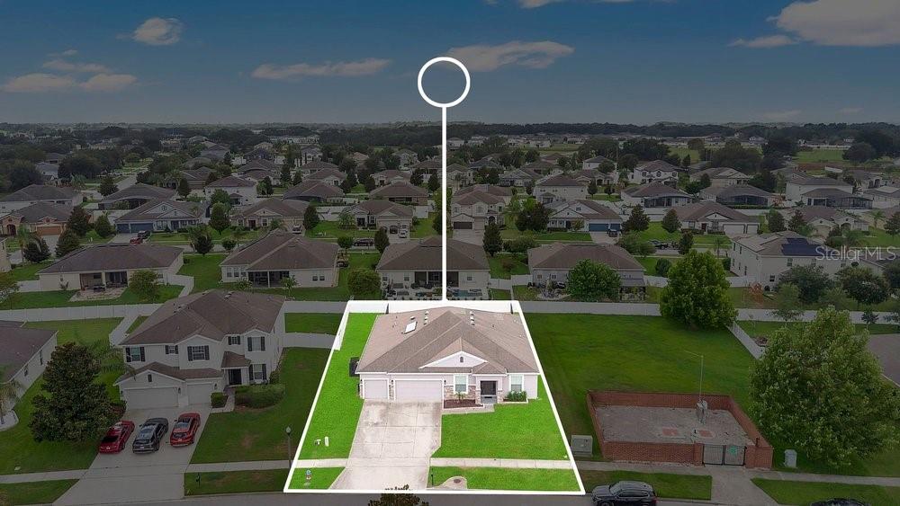 An aerial view shows a single-story house with a driveway and a large green lawn — 1086 ROCK CREEK STREET, APOPKA, FL