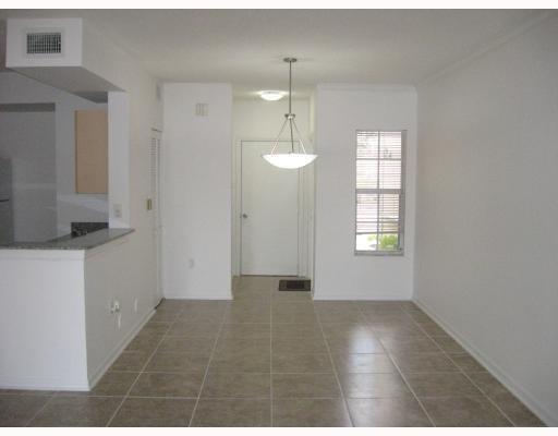A dining area with tile flooring, a hanging light fixture, and an adjacent kitchen counter — 2421 Centergate Drive # 104, Miramar FL 33025, MIRAMAR, FL