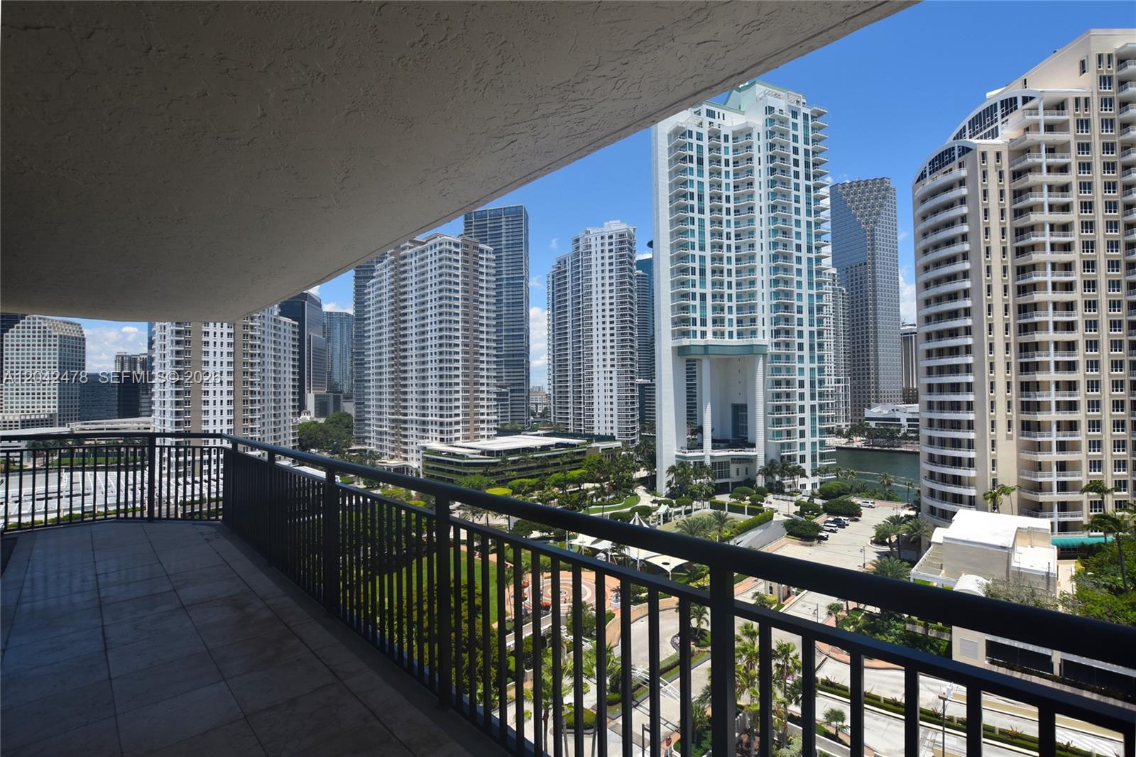 A balcony with a metal railing overlooks a city skyline with tall residential buildings — 540 Brickell Key Dr # 1513, Miami FL 33131, MIAMI, FL