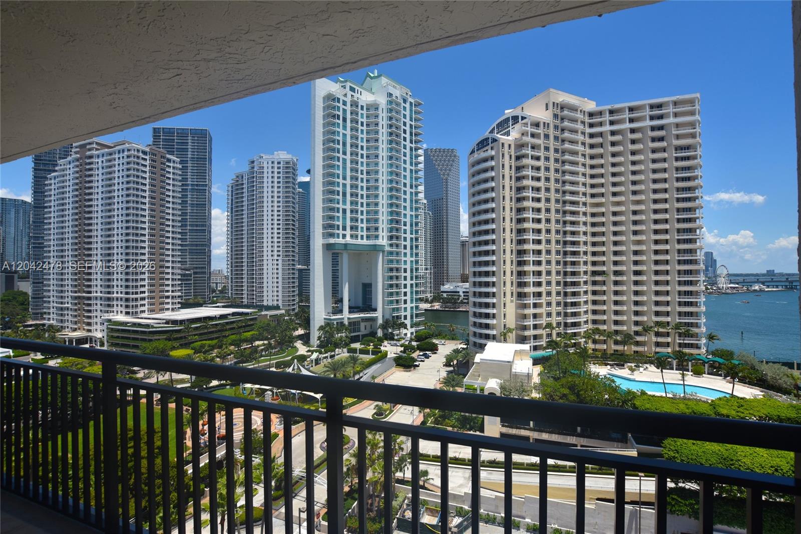 A balcony overlooks a park and high-rise buildings near a body of water — 540 Brickell Key Dr # 1513, Miami FL 33131, MIAMI, FL