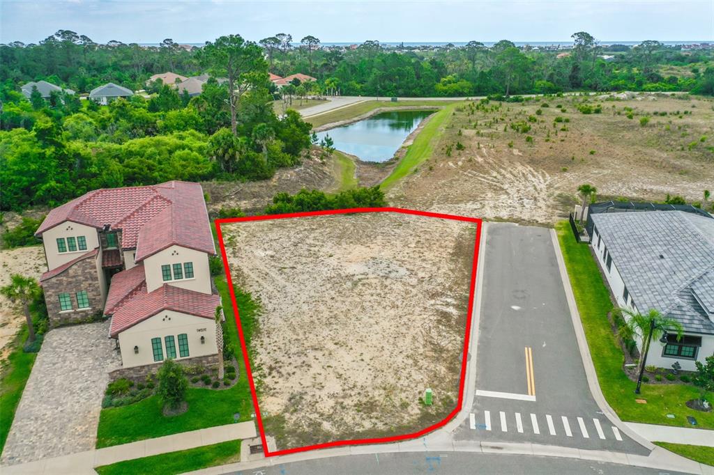 An aerial view shows a vacant residential lot outlined in red between two houses — 14 RIO VISTA DRIVE, PALM COAST, FL