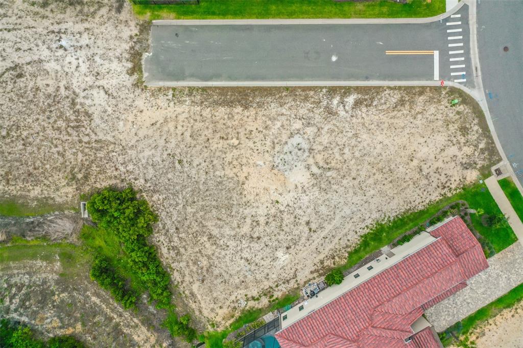 An aerial view shows a vacant, sandy residential lot situated next to a house — 14 RIO VISTA DRIVE, PALM COAST, FL