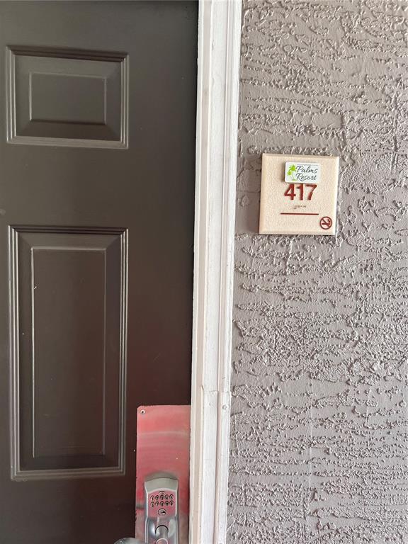 A brown door with a keypad lock sits next to a sign labeled Palms Resort 417 — 3100 PARKWAY BOULEVARD UNIT 417, KISSIMMEE, FL