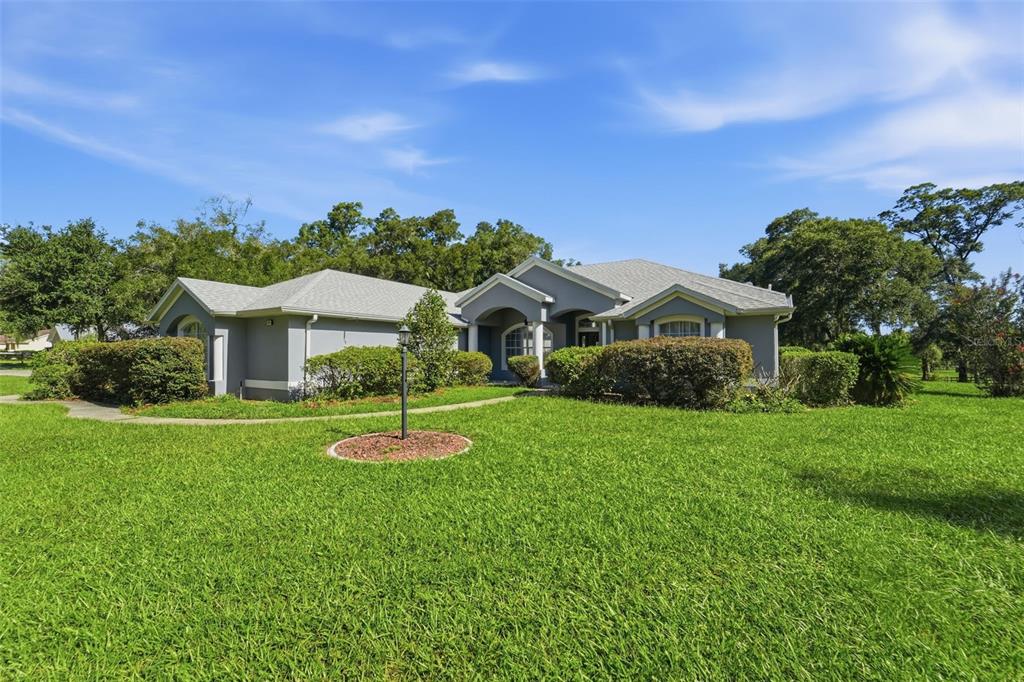 A single-story gray house with a shingled roof sits behind a large green lawn — 2111 SUN VALLEY LANE, DELAND, FL