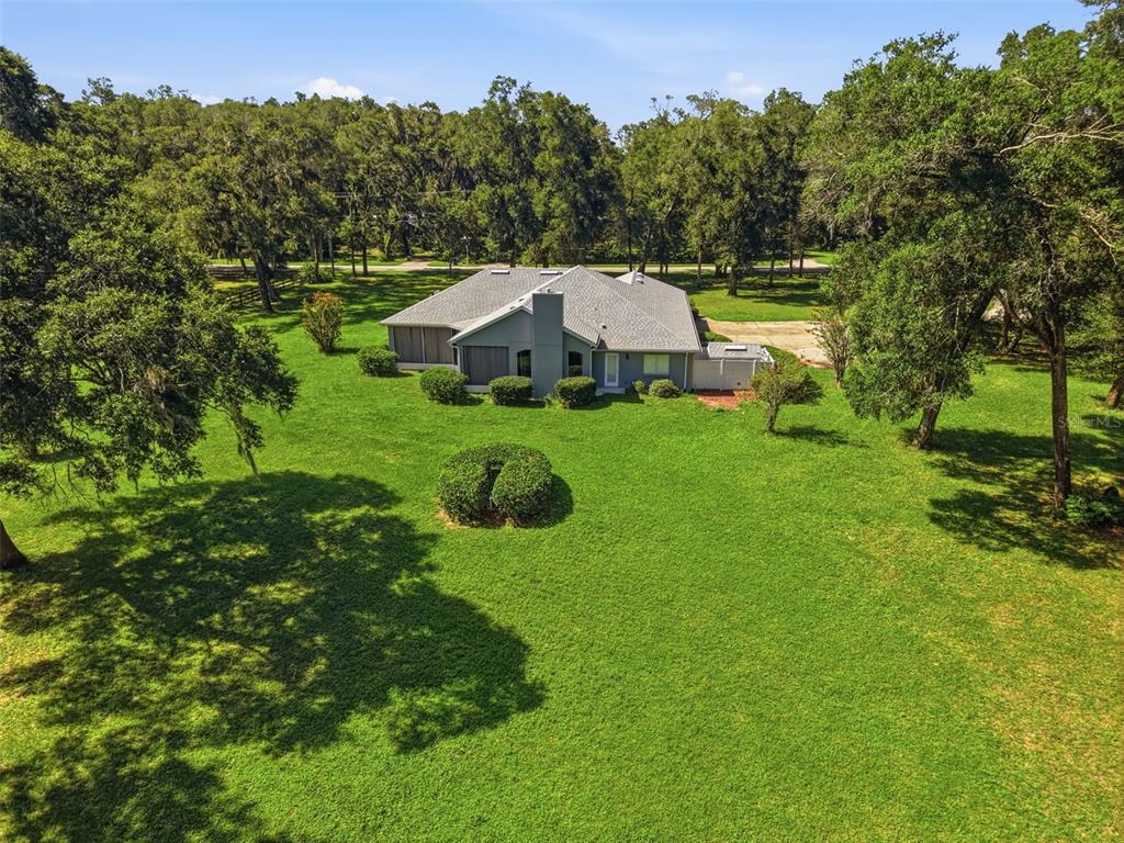 An aerial view shows a gray house with a shingled roof on a large lawn — 2111 SUN VALLEY LANE, DELAND, FL
