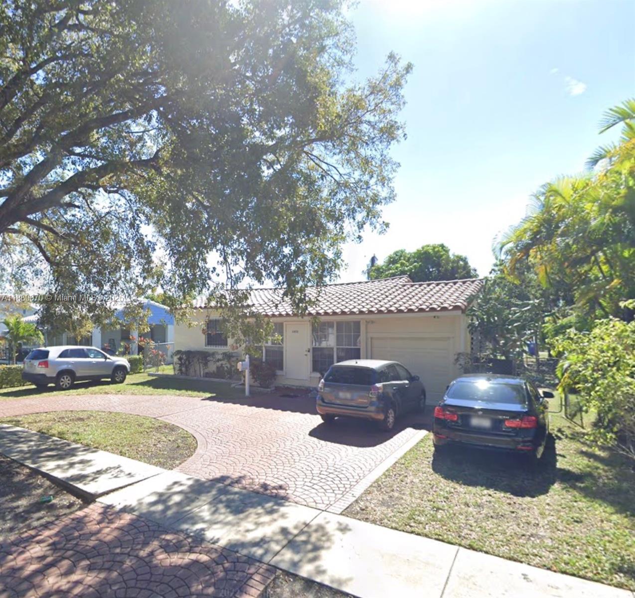 A single-story house with a tiled roof and a circular paved driveway sits under trees — 1852 Fletcher St, Hollywood FL 33020, HOLLYWOOD, FL